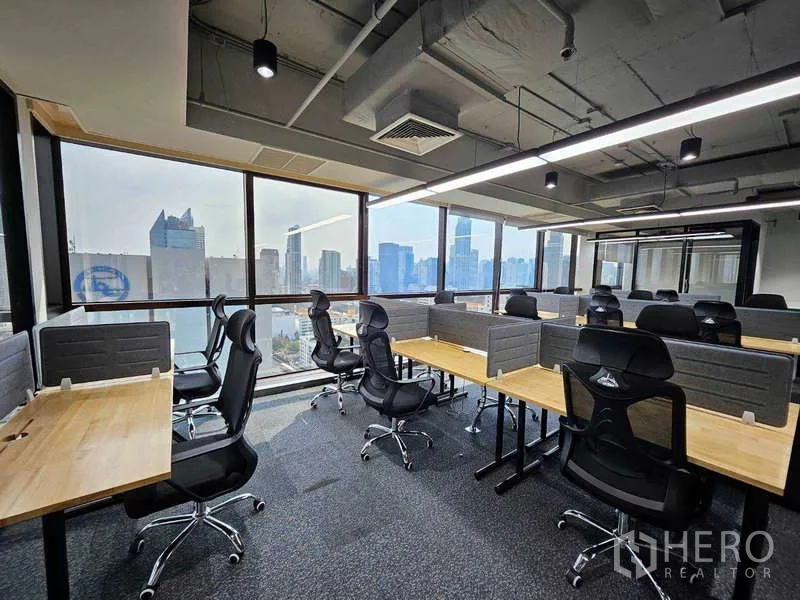 办公空间 出租在Ratchathewi, Bangkok - 开放式工区，隔间、网状椅与线性LED灯，背景为天际线