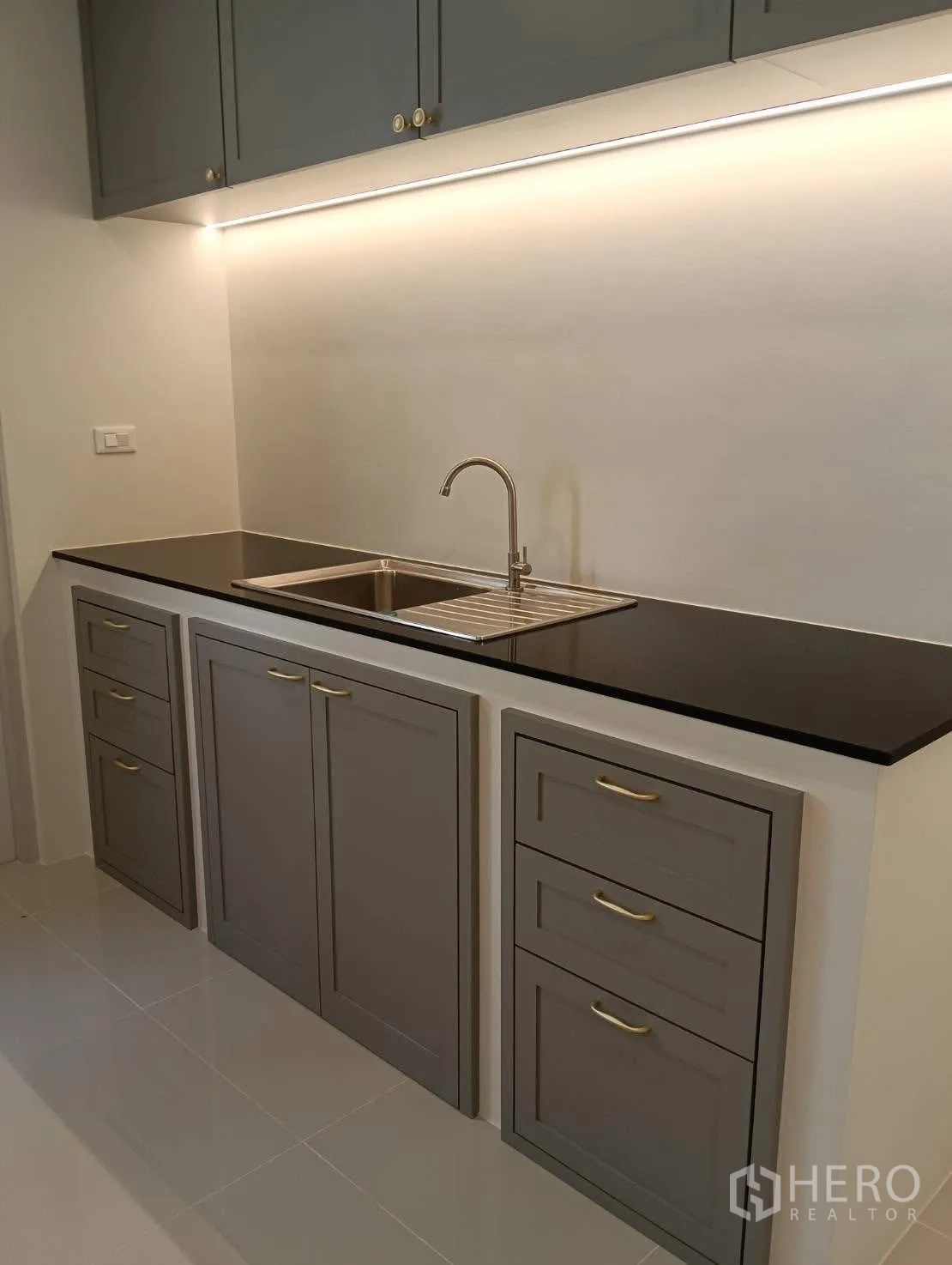 Detached House for rent in Bang Phli, Samut Prakan - Compact kitchen with black countertop, sink, and gray cabinets.