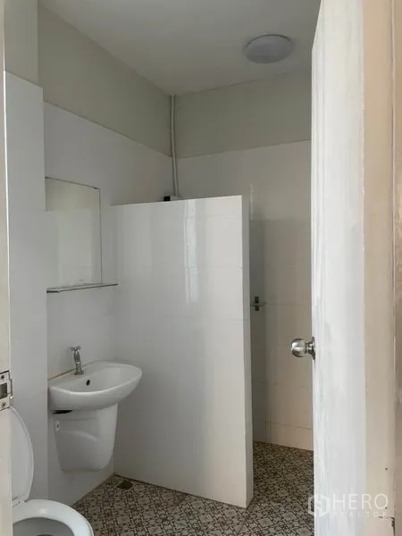 Detached House for rent in Huai Khwang, Bangkok - Simple bathroom with walk-in shower, white wall tiles and basic sanitary ware.