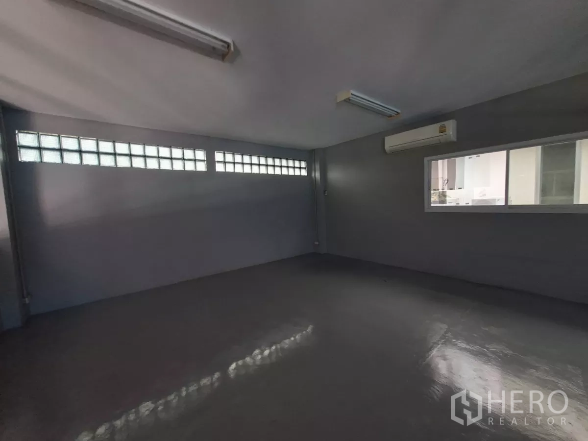Warehouse for rent in Suan Luang, Bangkok - Private office room with air conditioning, interior window and glass‑block clerestory.