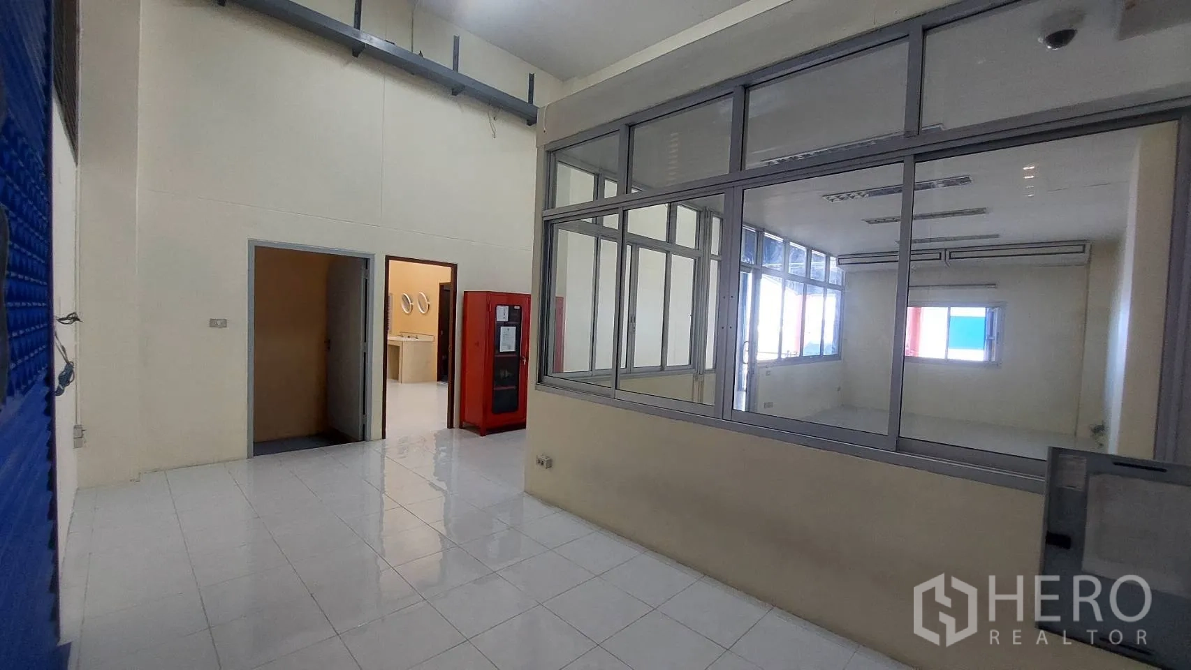 Warehouse for rent in Mueang Pathum Thani, Pathum Thani - Ground-floor office with glass partitions, restroom access, and service cabinet.