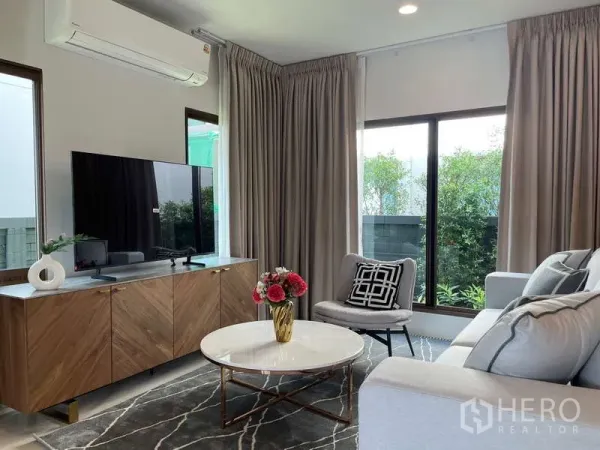 Detached House for rent in Bang Kapi, Bangkok - Cozy living room with TV console, marble coffee table and full-height curtains.