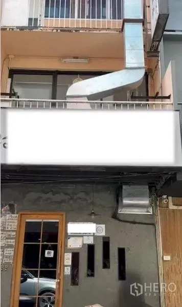 Shophouse for rent or sale in Watthana, Bangkok - Upper balcony of shophouse showing metal ventilation duct, railings and canopy above the entrance.