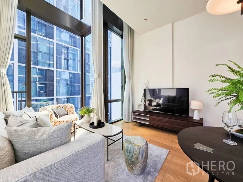 Condominium for rent - Living room corner with tall curtains, TV console, and panoramic glazing.