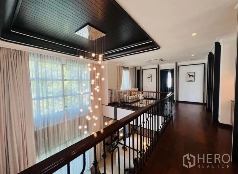 Detached House for rent or sale in Watthana, Bangkok - Upper landing gallery with modern drop chandelier overlooking the dining area.