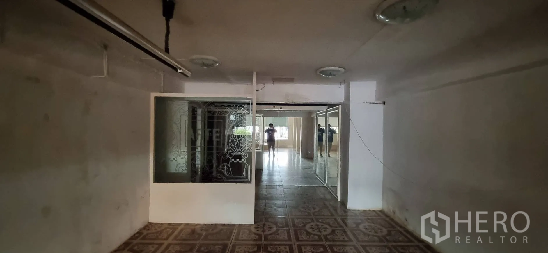 Shophouse for rent or sale in Bangkok - Deep interior room with patterned floor tiles and a decorative etched glass partition.