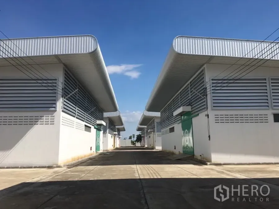 Warehouse for rent in Nong Chok, Bangkok - Row of new warehouse units facing a wide internal driveway inside a secure compound.