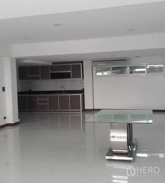 带办公室的家 出租在Khlong Toei, Bangkok - 宽敞的开放式起居区，亮面地板、玻璃桌与墙面一体式厨房