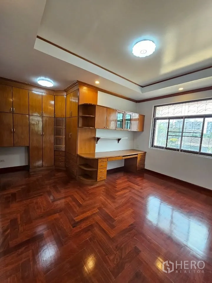 Home Office for rent in Wang Thonglang, Bangkok - Bedroom or office with extensive built‑in wooden cabinets and study desk.