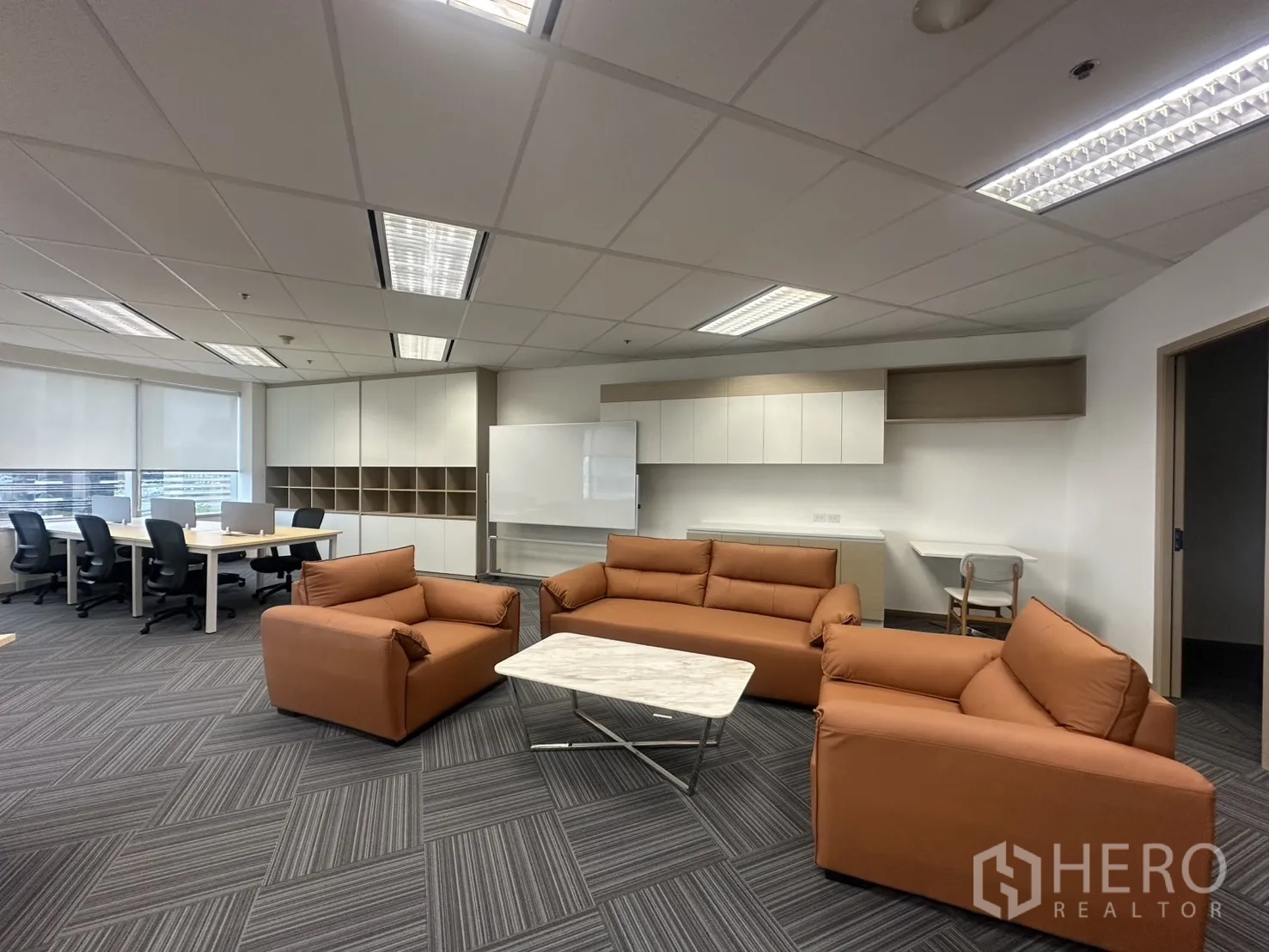 Office Space for rent in Pathum Wan, Bangkok - Lounge zone with armchairs, a sofa, and marble table beside workstations.