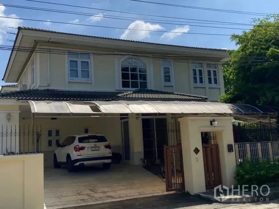 Detached House for rent in Prawet, Bangkok - Front elevation of the home with driveway parking under a canopy roof.