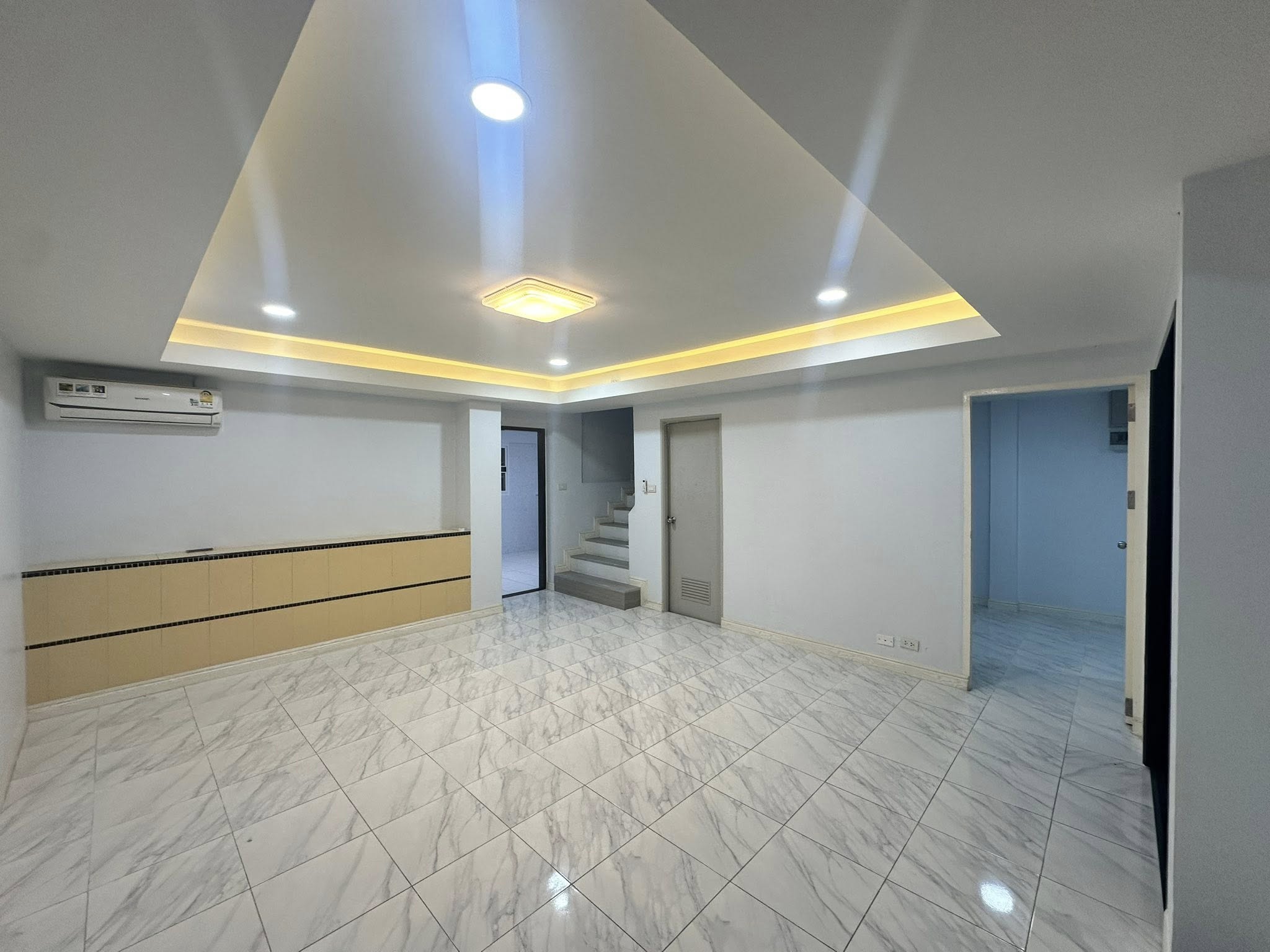 Home Office for rent in Wang Thonglang, Bangkok - Main living area with marble-look tiles and cove lighting ceiling.