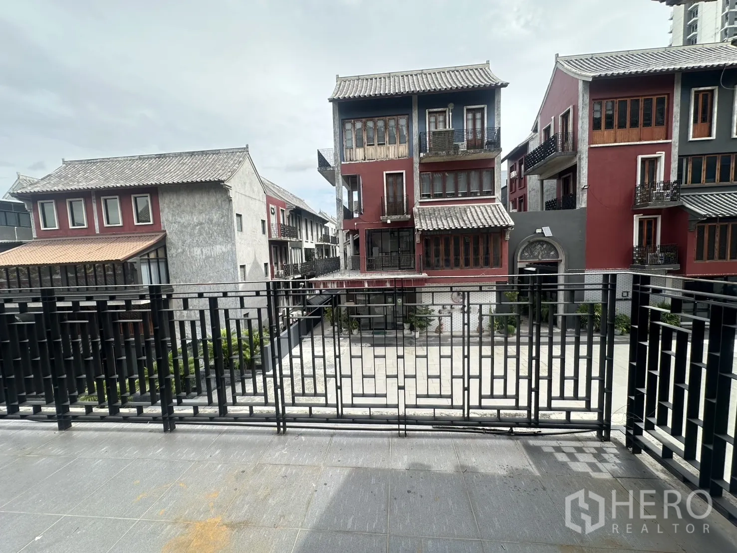 Home Office for rent in Pathum Wan, Bangkok - Balcony view across a courtyard to low-rise buildings with gabled roofs.