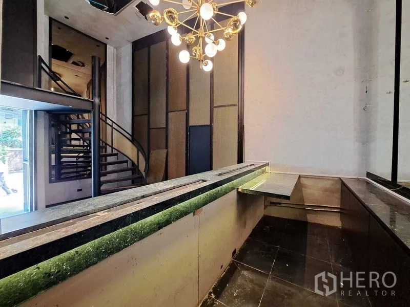 Retail Space for rent in Watthana, Bangkok - Ground-floor marble bar with modern chandelier and spiral staircase in a double-height retail lobby.