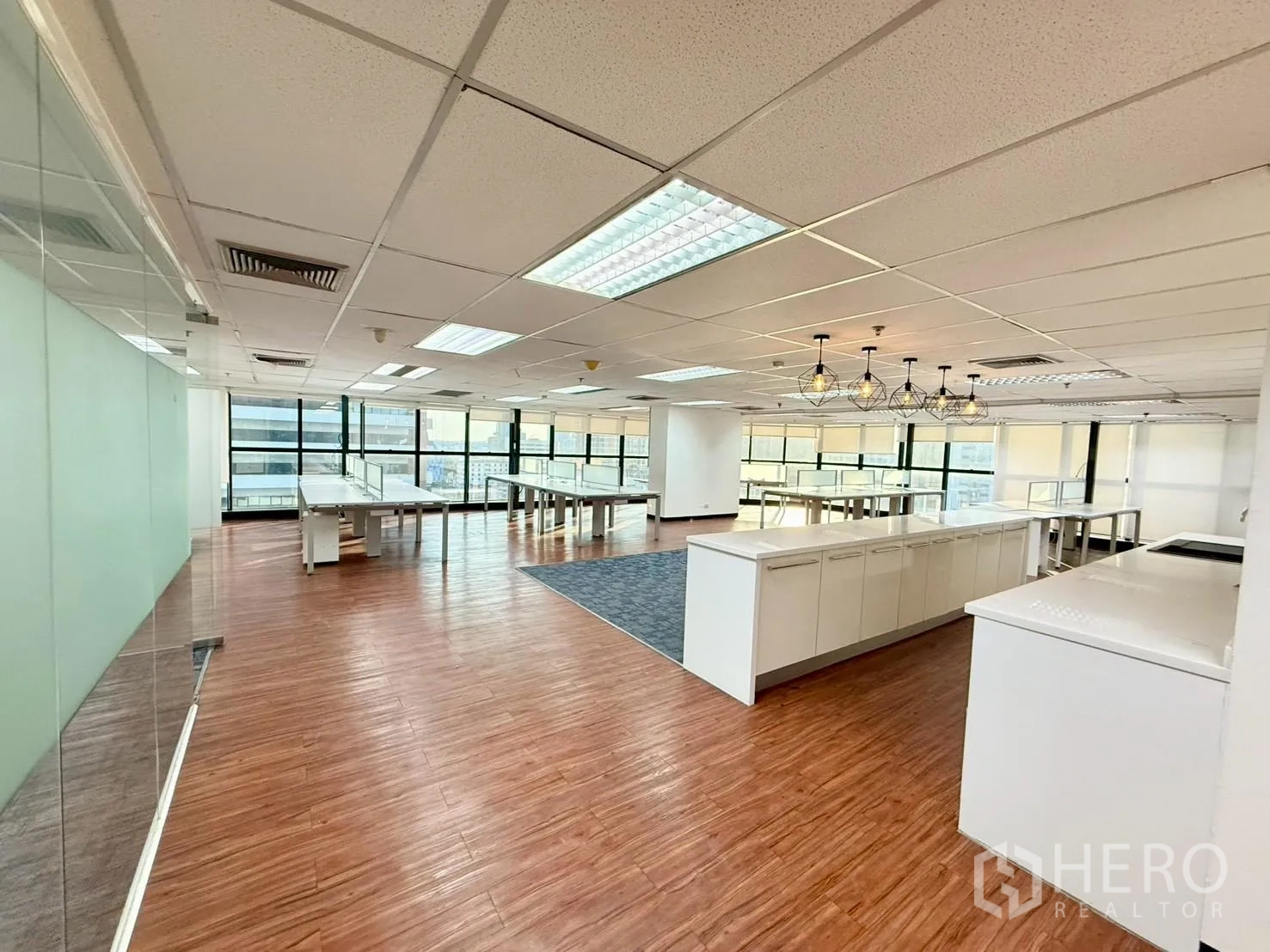 Office Space for rent in Watthana, Bangkok - Spacious office showing long pantry counter, glass partitions, wood floors, and city views.