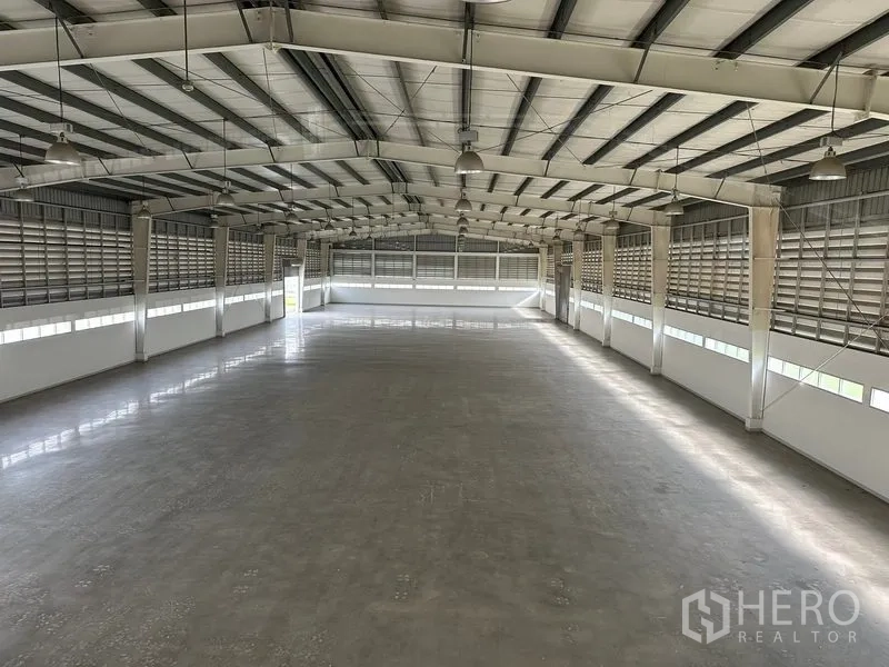 Factory for rent in Phra Nakhon Si Ayutthaya - Elevated view across the warehouse showing high-ceiling, polished floor, and evenly spaced lights.