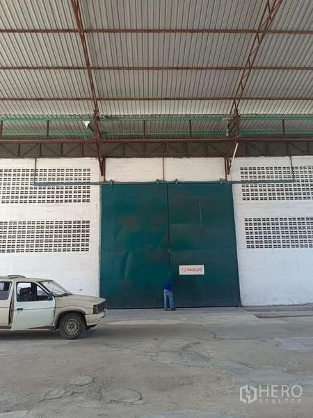 Warehouse for rent in Mueang Rayong, Rayong - Tall green sliding door on the warehouse facade beneath a metal canopy.