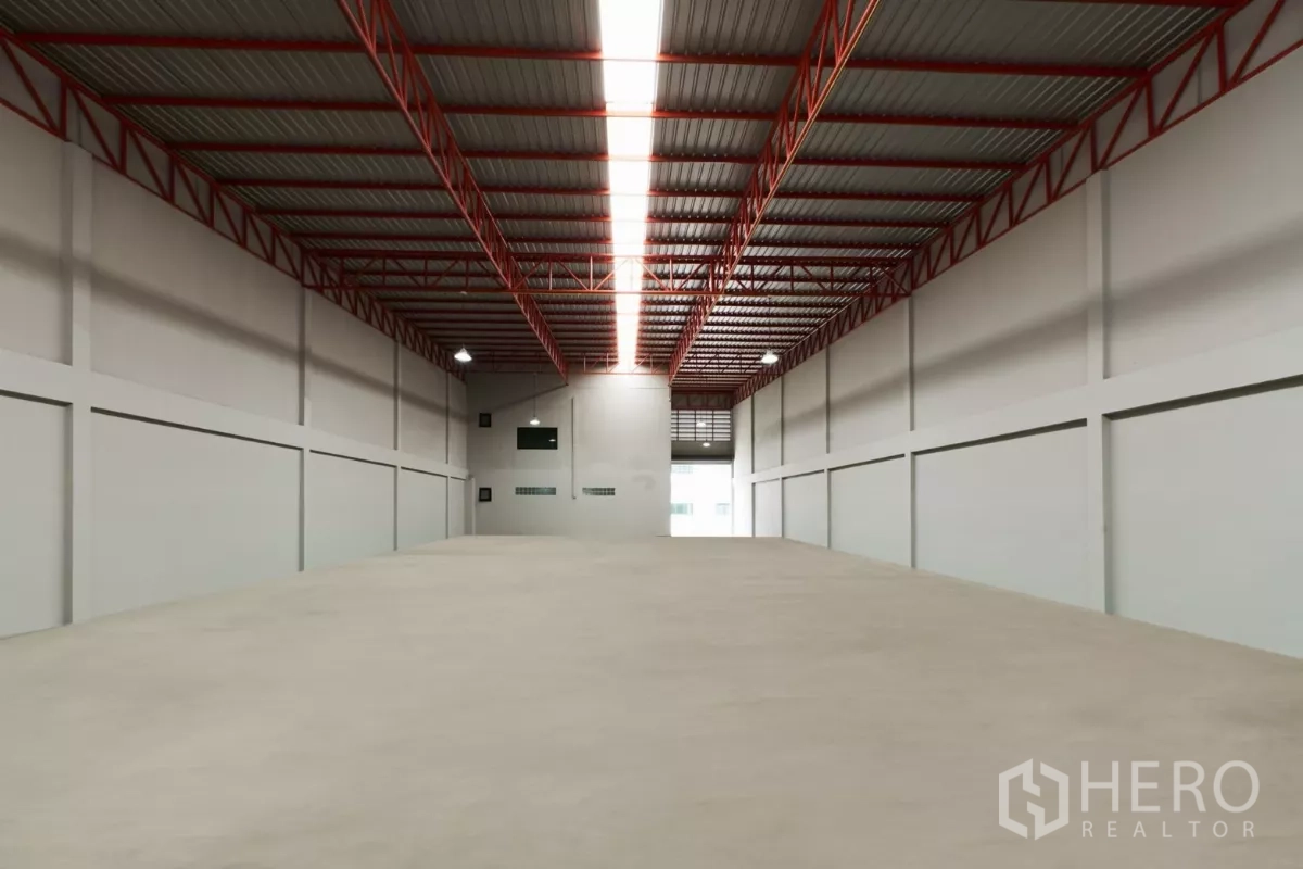 Factory for rent in Mueang Samut Sakhon, Samut Sakhon - View from the back toward the entrance roller door under a bright central skylight.