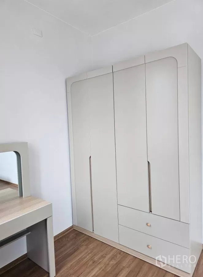 Townhouse for rent in Bang Phli, Samut Prakan - Dressing area with large wardrobe and vanity table in soft neutral tones.