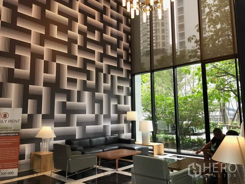 Condominium for rent in Khlong Toei, Bangkok - Double-height lobby with geometric feature wall and lounge seating.