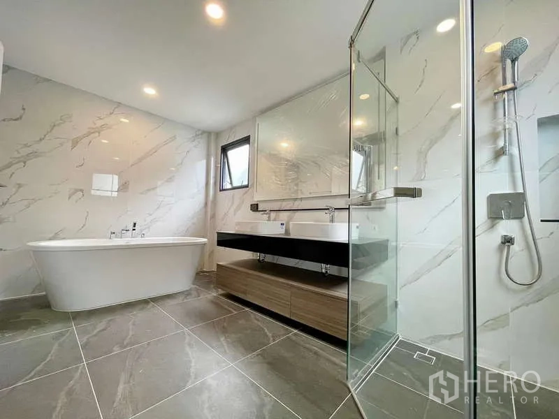 Detached House for rent in Bang Phli, Samut Prakan - Master bathroom with freestanding tub, double vanity and glass shower enclosure.