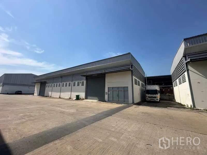 Warehouse for rent in Bang Bua Thong, Nonthaburi - Modern warehouse exterior with wide concrete yard and loading bay in Bang Bua Thong, Nonthaburi