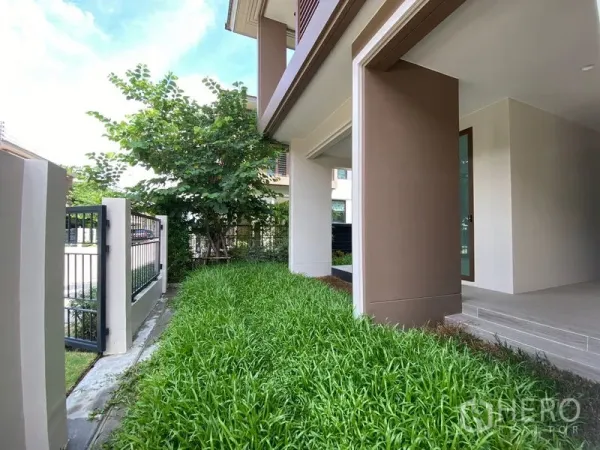 Detached House for rent in Bang Kapi, Bangkok - Side garden strip with lush grass and metal fence along the house.