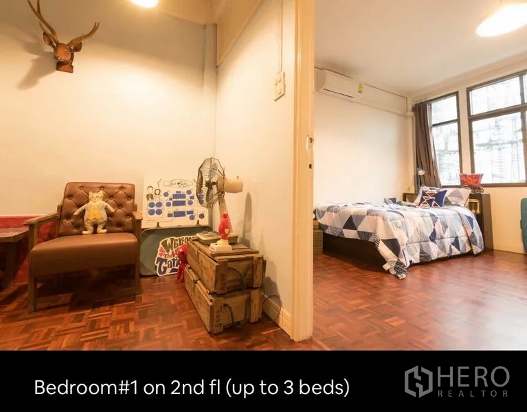 Townhouse for rent in Khlong Toei, Bangkok - Entrance to second-floor bedroom with seating area and parquet floors leading to a bright sleeping space.