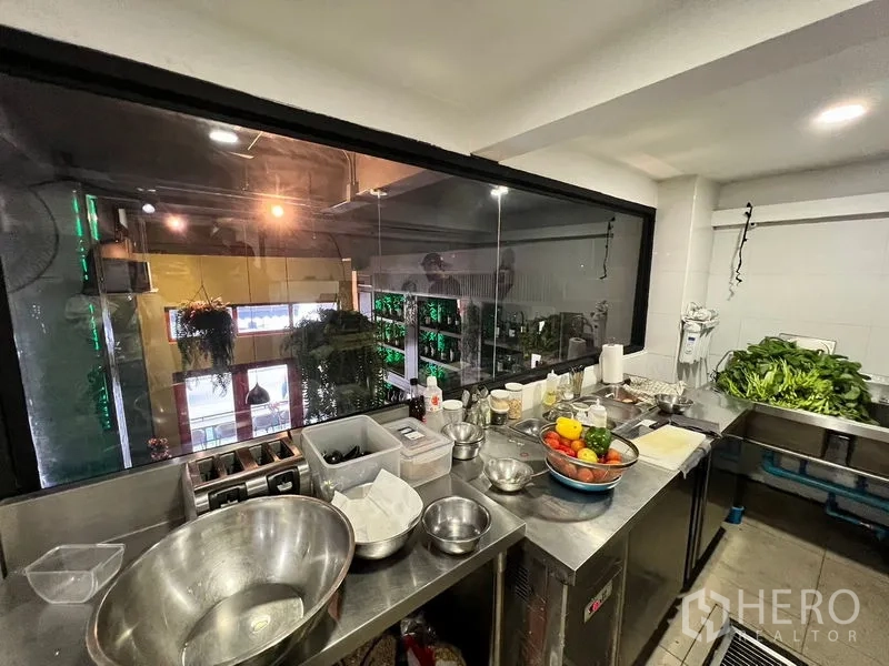 อาคารพาณิชย์ ให้เช่าในWatthana, Bangkok - ห้องเตรียมอาหารสเตนเลส มีช่องส่งอาหารมองเห็นพื้นที่ดับเบิลโวลต์และต้นไม้แขวน.