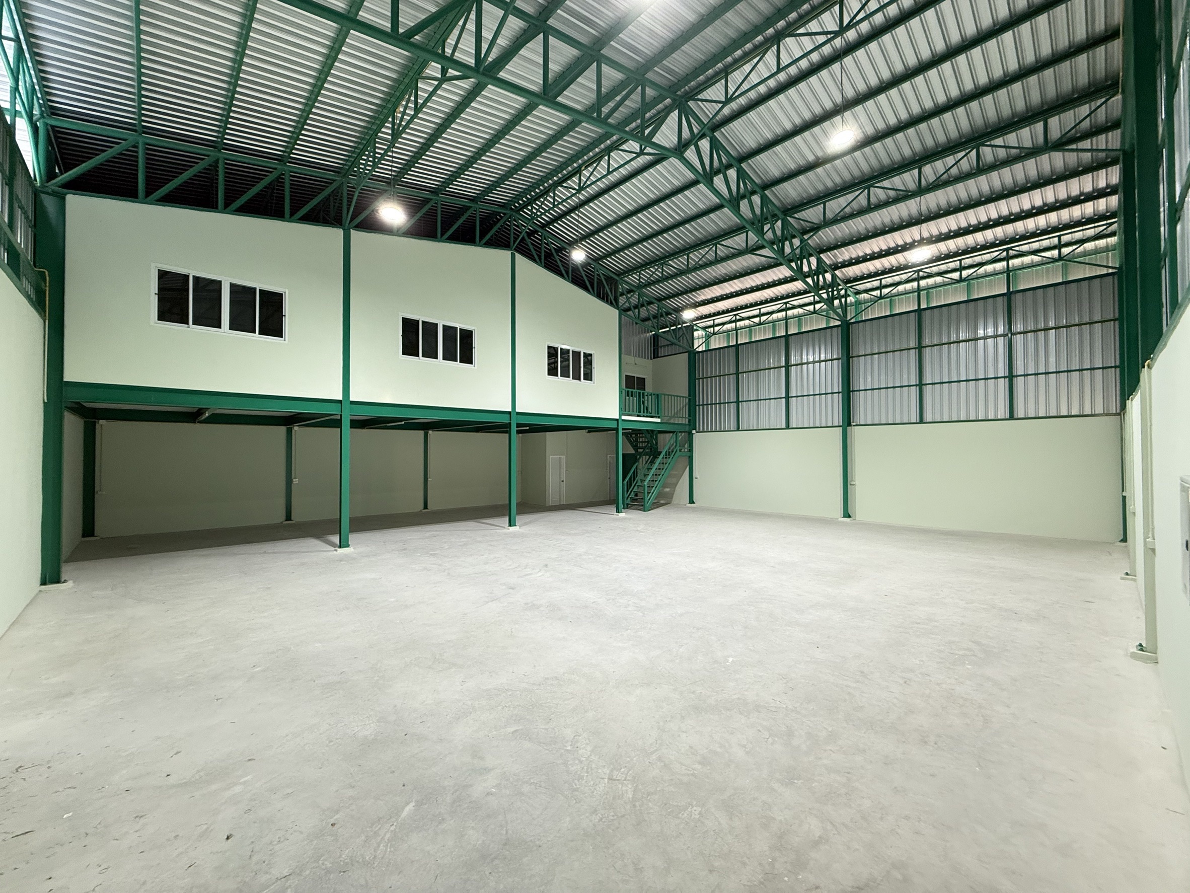 Warehouse for rent in Lat Krabang, Bangkok - Spacious high-ceiling warehouse interior with green steel trusses and mezzanine office.