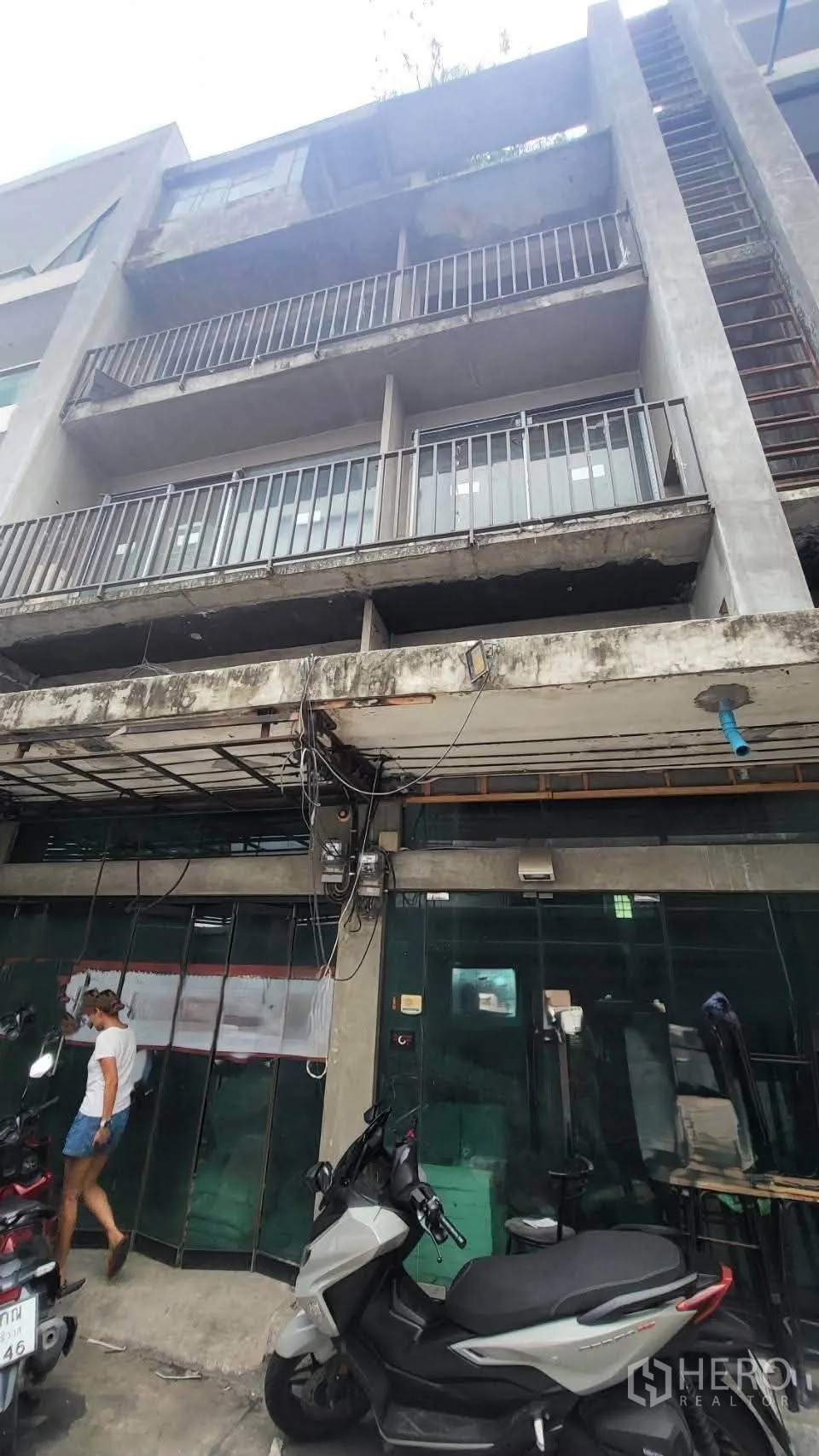 Shophouse for rent in Khlong Toei, Bangkok - Multi-storey shophouse exterior with balconies and a glass storefront.
