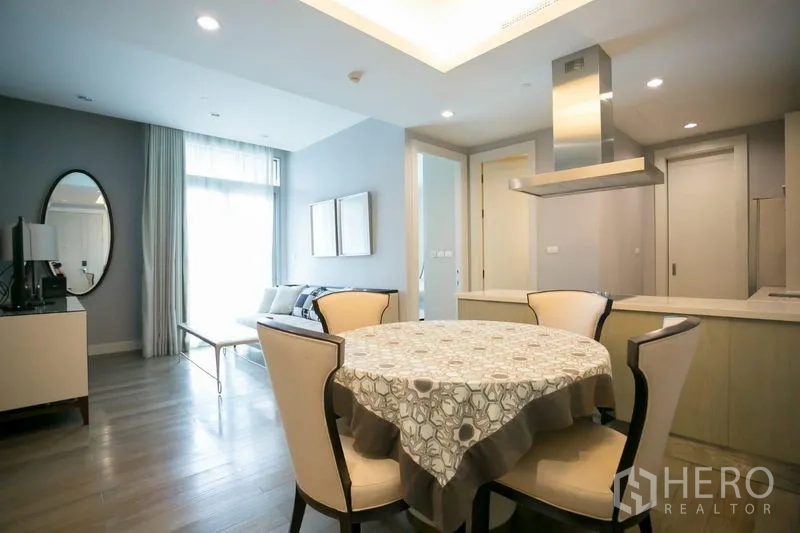 Condominium for rent or sale in Pathum Wan, Bangkok - Dining nook with round table under a tray ceiling beside the modern kitchen.