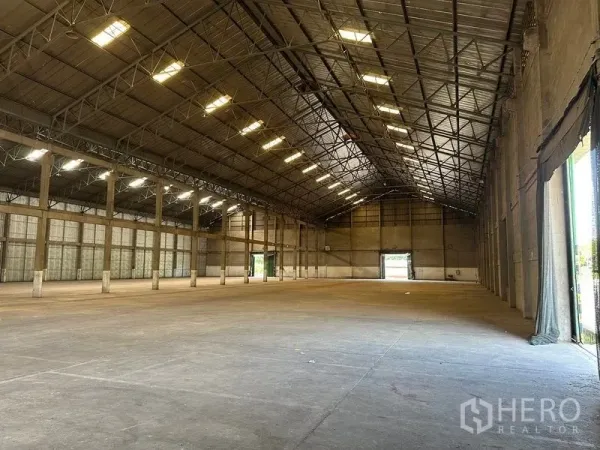 Warehouse for rent in Mueang Pathum Thani, Pathum Thani - Long clear‑span hall with multiple loading doors at both ends and ample natural light.