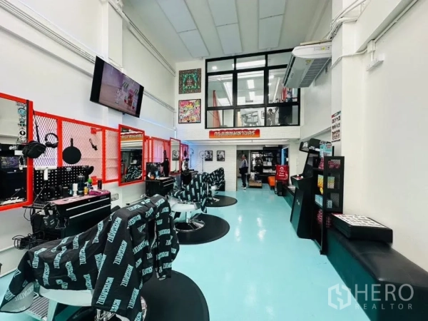 Shophouse for sale in Watthana, Bangkok - Long double-height hall fitted as a salon with multiple stations, mezzanine windows, and air-conditioning.