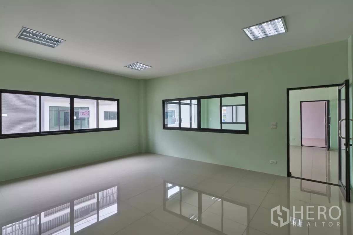 Factory for rent in Mueang Samut Sakhon, Samut Sakhon - Bright office room with large window and reflective tiled floor.