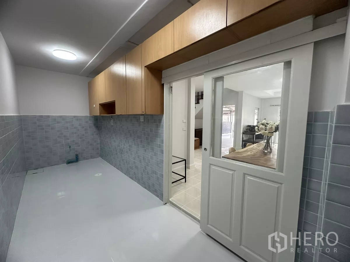 Townhouse for sale in Lam Luk Ka, Pathum Thani - Separate kitchen with upper cabinets and sliding glass door.