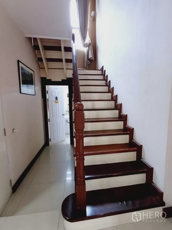 Detached House for rent or sale in Mueang Nonthaburi, Nonthaburi - Staircase with wooden steps and handrail leading to the upper floor.