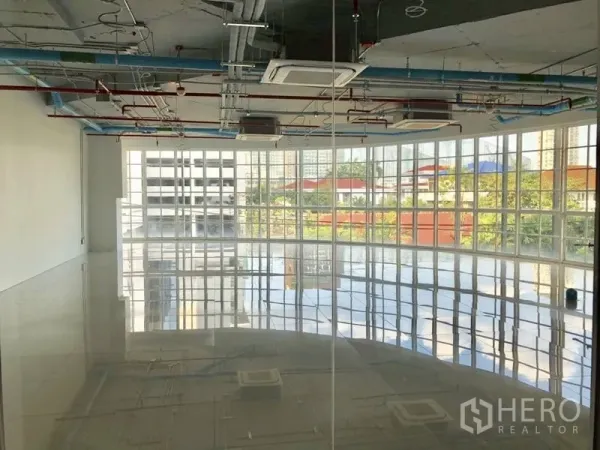 Retail Space for rent in Khlong Toei, Bangkok - Bright open-plan retail space with glossy tiles, panoramic windows, and ceiling cassette air-conditioning.