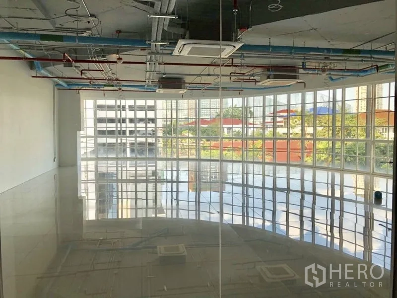 Retail Space for rent in Khlong Toei, Bangkok - Bright open-plan retail space with glossy tiles, panoramic windows, and ceiling cassette air-conditioning.