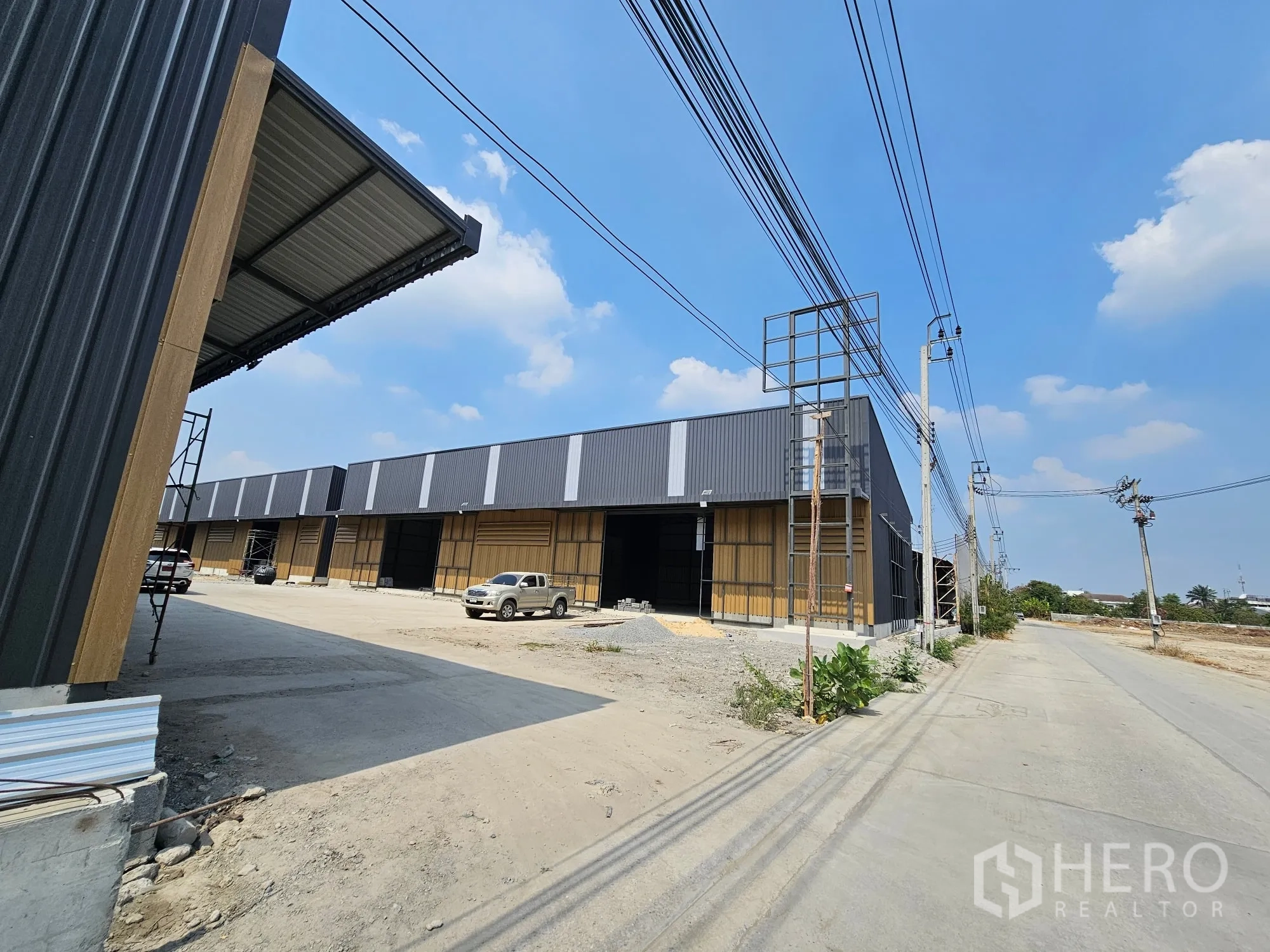 Warehouse for rent in Bang Khen, Bangkok - Exterior view of a warehouse row with an ample yard and access road.
