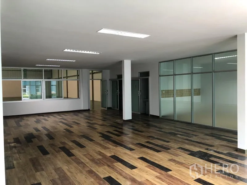 工厂 出租在Samut Prakan - 宽敞办公区，多间玻璃房、顶灯与木纹地板。