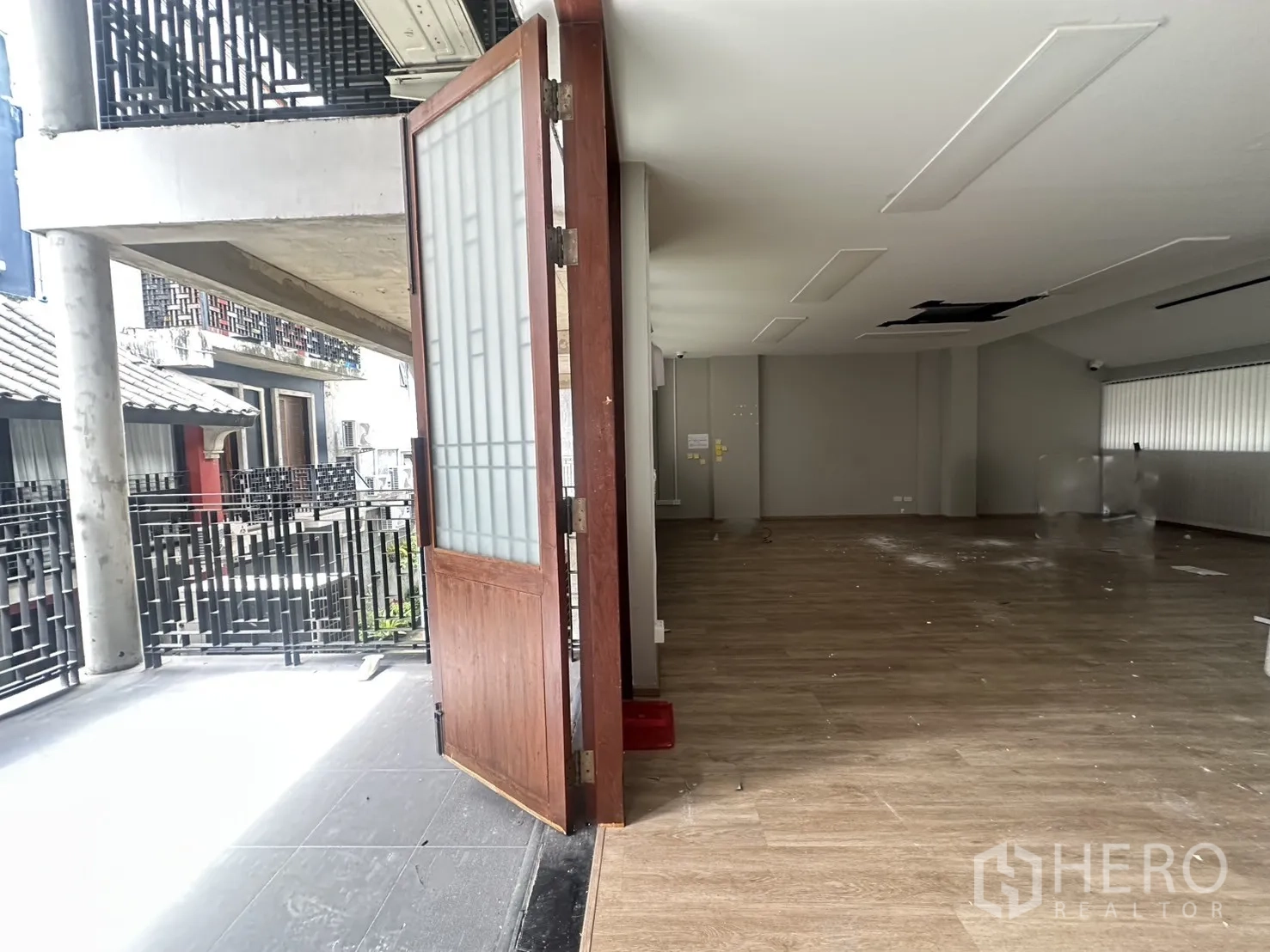Home Office for rent in Pathum Wan, Bangkok - Large terrace connected to the interior through a wooden door with open-plan space inside.