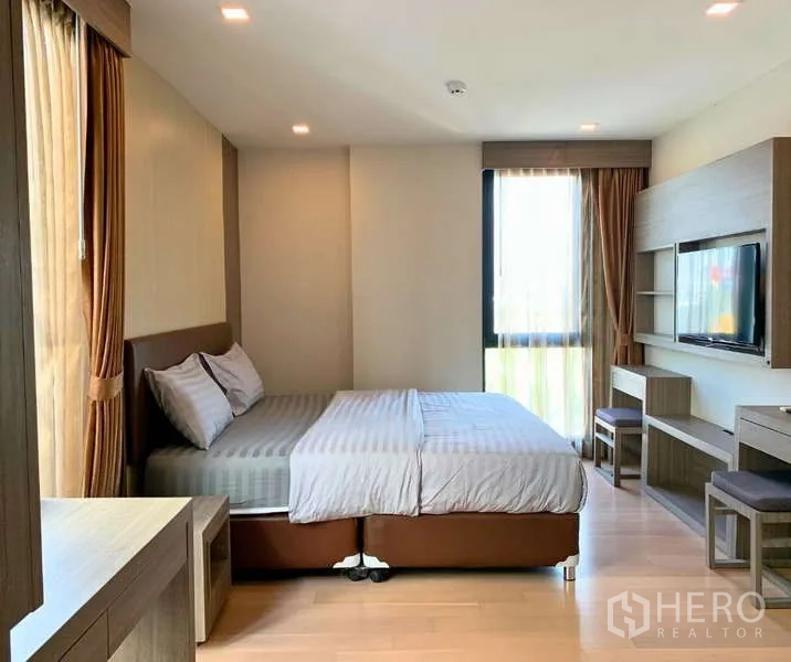 Condominium for rent - Spacious master bedroom with bed, TV wall, work desk, and large windows.