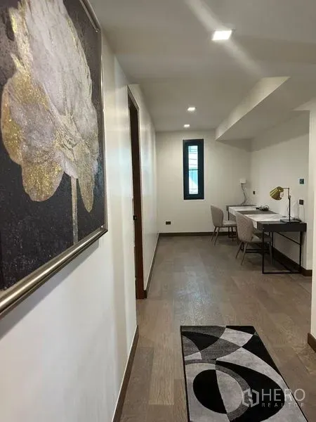 独立式住宅 出租在Suan Luang, Bangkok - 明亮走廊，设书桌与装饰画，木地板。