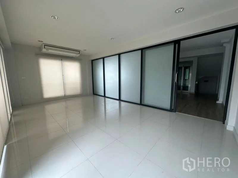 Home Office for rent in Suan Luang, Bangkok - Bright tiled multifunction room with sliding frosted panels and air conditioner.