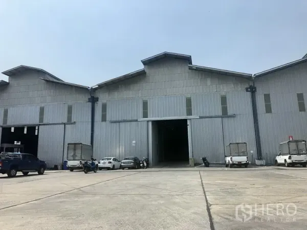 Warehouse for rent in Pak Kret, Nonthaburi - Wide exterior view of a warehouse complex with multiple loading bays and on-site parking in Pak Kret, Nonthaburi.