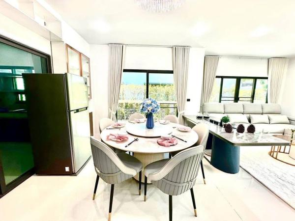 Detached House for rent in Bang Kapi, Bangkok - Dining area with round table set for six beside large windows and garden view.