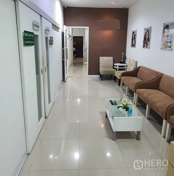 Home Office for rent in Chatuchak, Bangkok - Hallway with waiting area seating and sliding doors leading to treatment rooms.