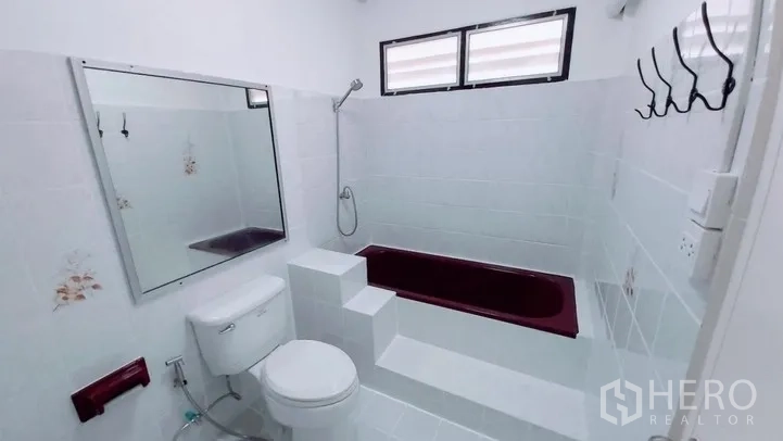 Townhouse for sale - Bathroom with elevated soaking tub, white tiles and window.