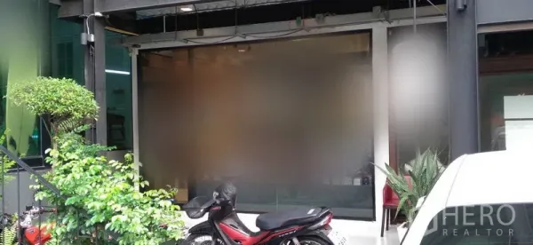 Retail Space for rent in Watthana, Bangkok - Shopfront with frosted glass panel, potted greenery and motorbike parking at the entrance.